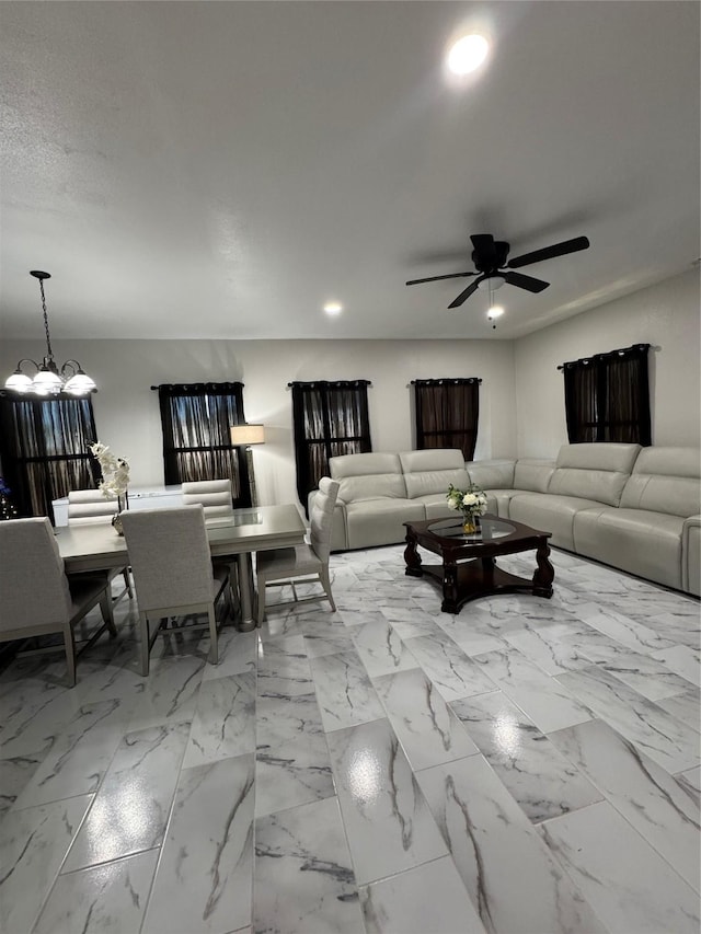 living room featuring ceiling fan with notable chandelier