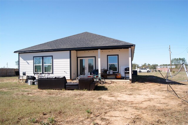 rear view of property featuring french doors and a lawn