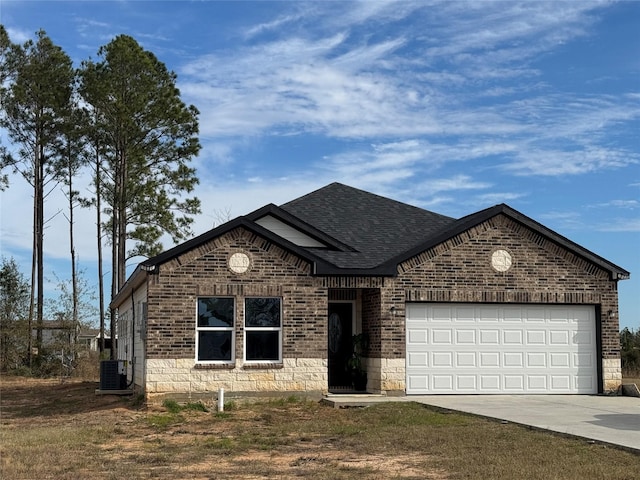 view of front of property with central air condition unit and a garage