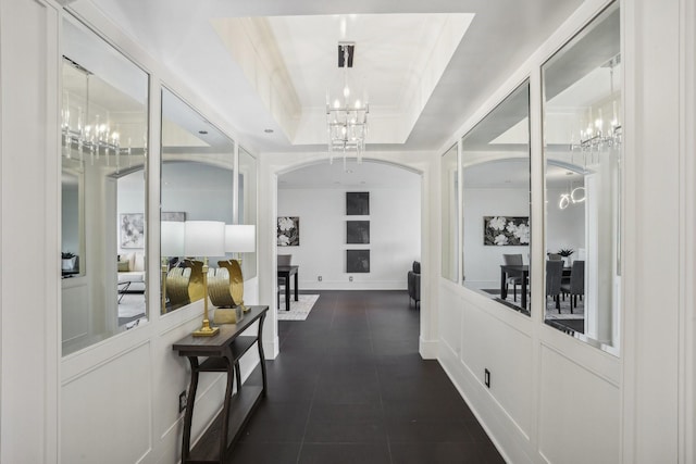 121 N Post Oak Ln Unit 1805, Houston, TX 77024 - corridor featuring arched walkways, dark tile patterned flooring, a raised ceiling, an inviting chandelier, and a decorative wall