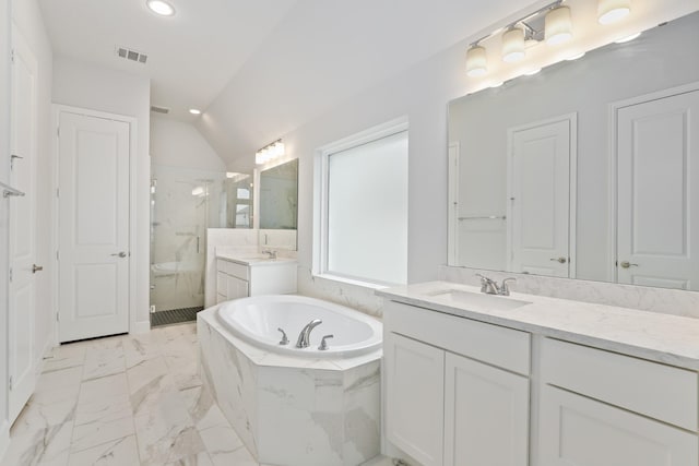 bathroom with vaulted ceiling, independent shower and bath, and vanity