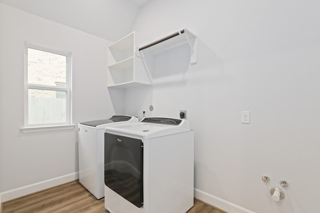 washroom featuring washer and dryer, a healthy amount of sunlight, and light wood-type flooring