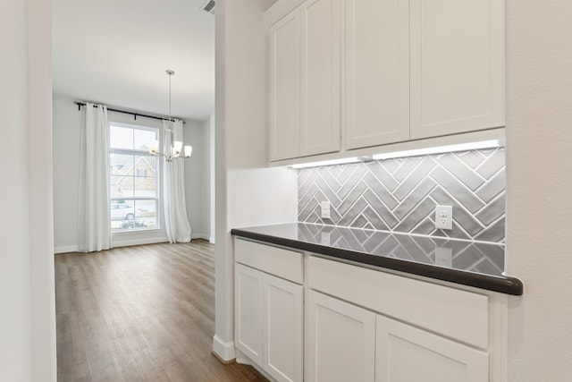 kitchen with white cabinetry, a chandelier, and pendant lighting