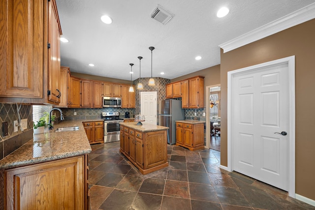 kitchen with pendant lighting, a kitchen island, backsplash, appliances with stainless steel finishes, and sink