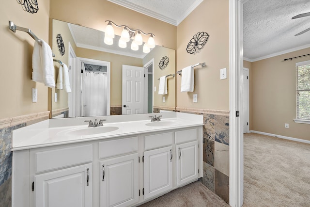 bathroom with a textured ceiling, ceiling fan, crown molding, and vanity