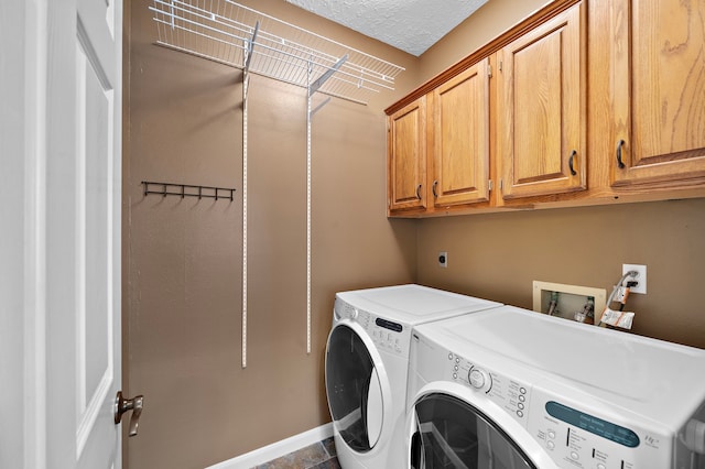 washroom with washer and dryer, cabinets, and a textured ceiling