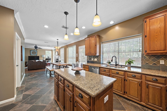 kitchen with sink, ceiling fan, stainless steel dishwasher, a kitchen island, and pendant lighting