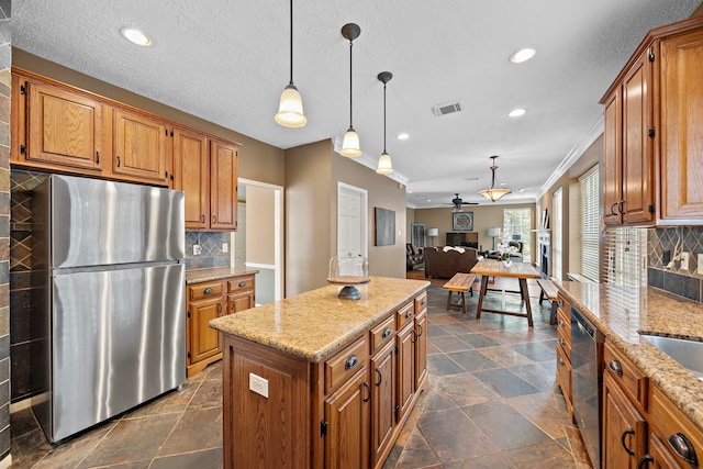 kitchen with stainless steel appliances, a center island, ceiling fan, backsplash, and hanging light fixtures