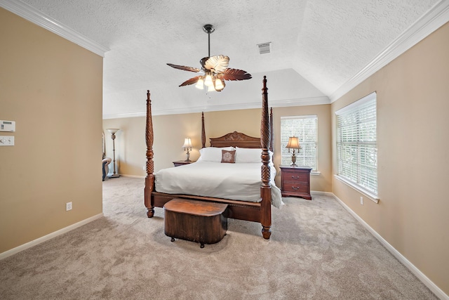 carpeted bedroom featuring ceiling fan, vaulted ceiling, crown molding, and a textured ceiling