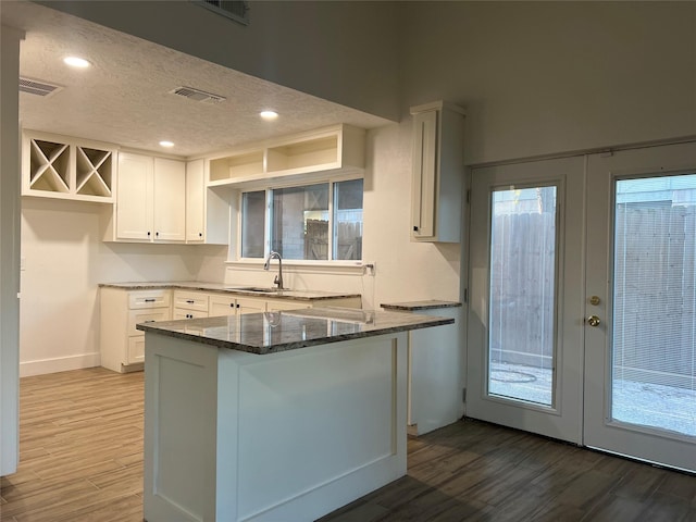 kitchen with french doors, white cabinetry, dark stone countertops, and dark hardwood / wood-style floors