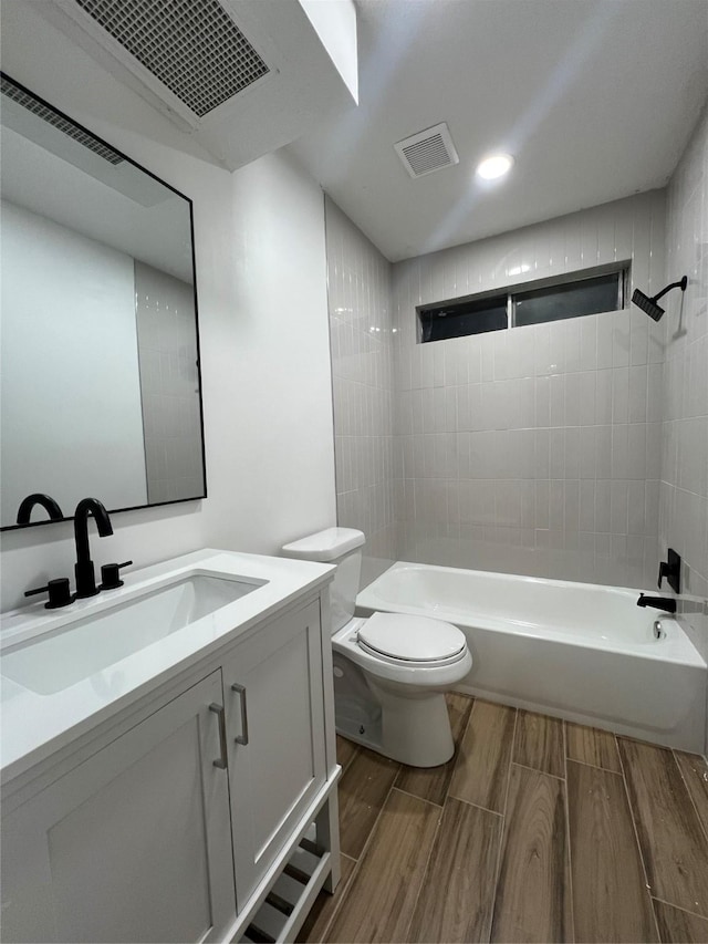 full bathroom featuring toilet, vanity, and tiled shower / bath