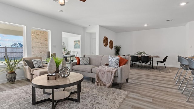 living room featuring ceiling fan and light hardwood / wood-style flooring