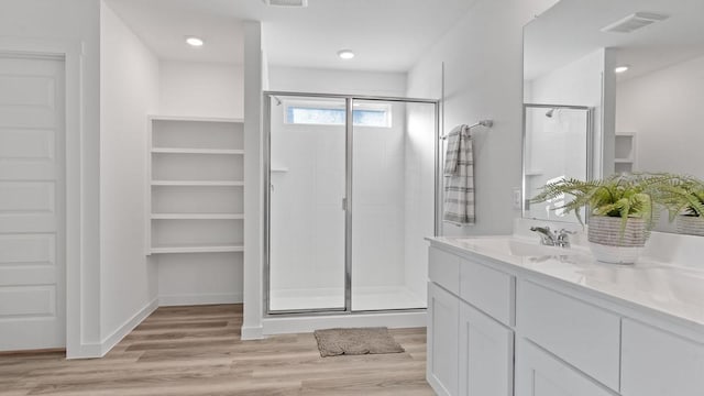 bathroom featuring vanity, wood-type flooring, and walk in shower