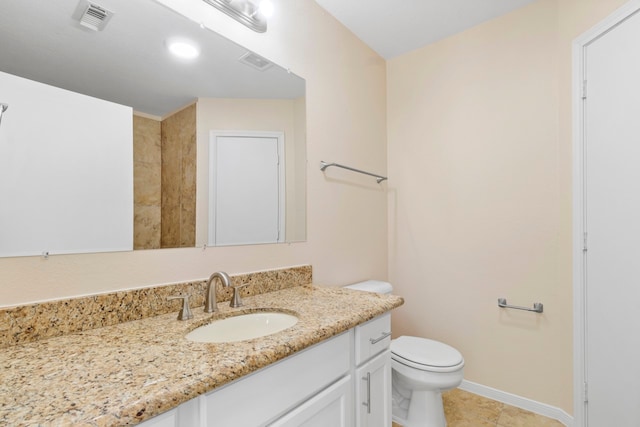 bathroom featuring toilet, vanity, and tile patterned floors