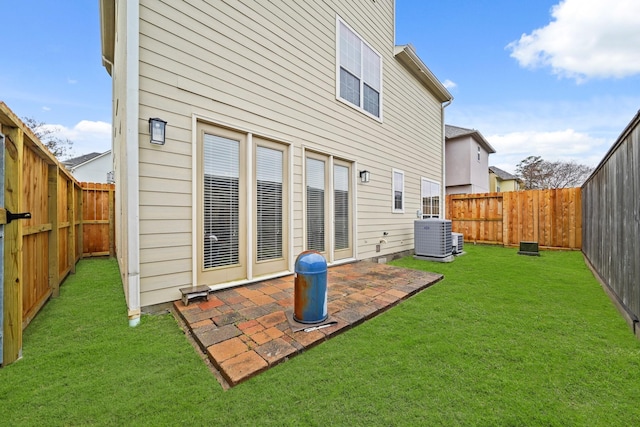 back of house featuring central AC unit, a lawn, and a patio area