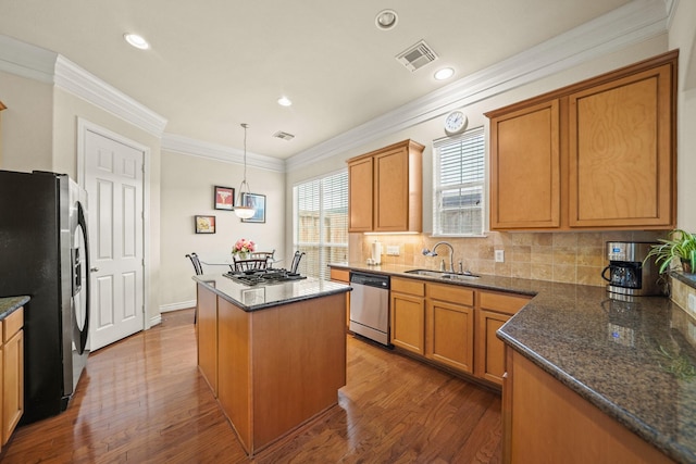 kitchen with stainless steel appliances, dark hardwood / wood-style flooring, pendant lighting, a kitchen island, and sink