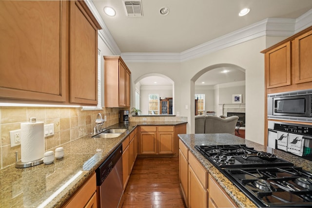 kitchen featuring appliances with stainless steel finishes, ornamental molding, dark wood-type flooring, decorative backsplash, and sink