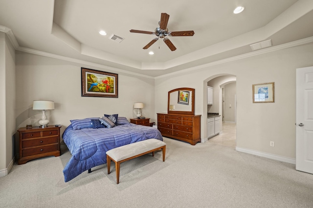 bedroom with ceiling fan, a tray ceiling, and crown molding