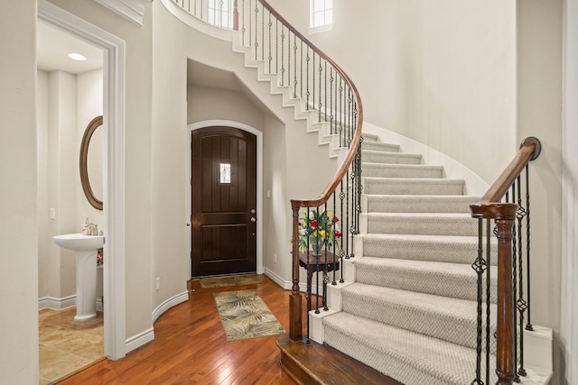 entryway with sink, a high ceiling, and hardwood / wood-style flooring