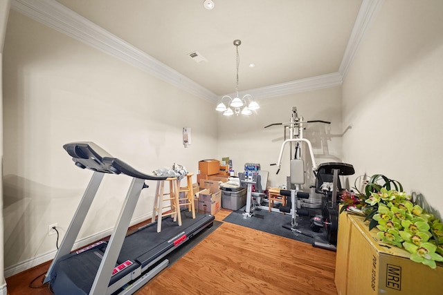 workout room featuring ornamental molding, a chandelier, and wood-type flooring