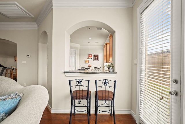 kitchen with crown molding, dark stone counters, and dark hardwood / wood-style floors