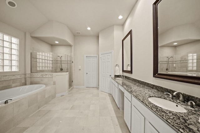 bathroom with vanity, vaulted ceiling, and plus walk in shower