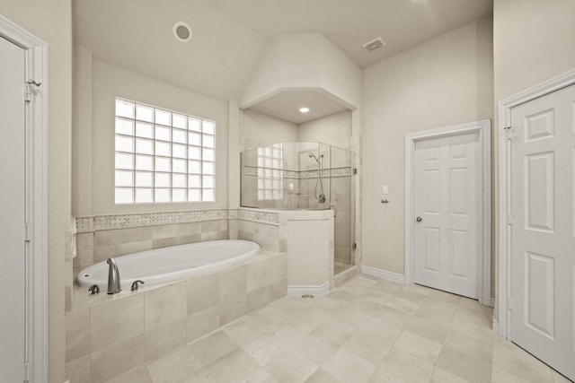 bathroom featuring lofted ceiling and separate shower and tub