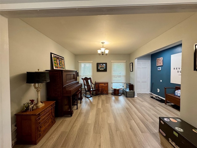 sitting room with an inviting chandelier, baseboards, and light wood finished floors