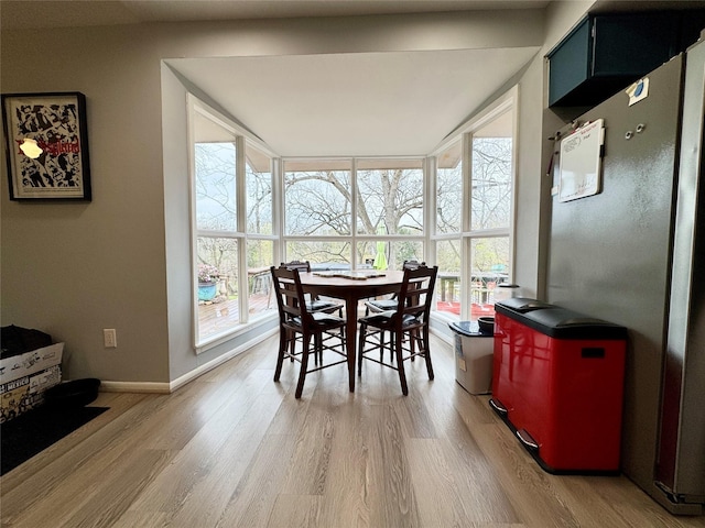 dining space with baseboards and light wood-style floors