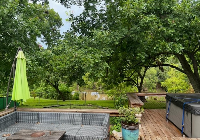 wooden terrace with a yard, fence, and a hot tub