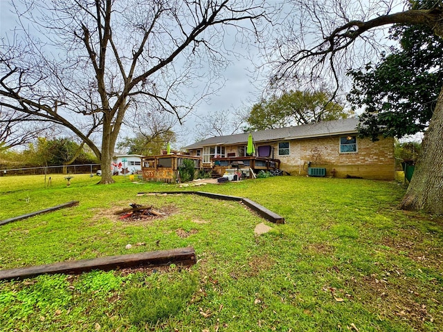 view of yard featuring a wooden deck, central air condition unit, and fence