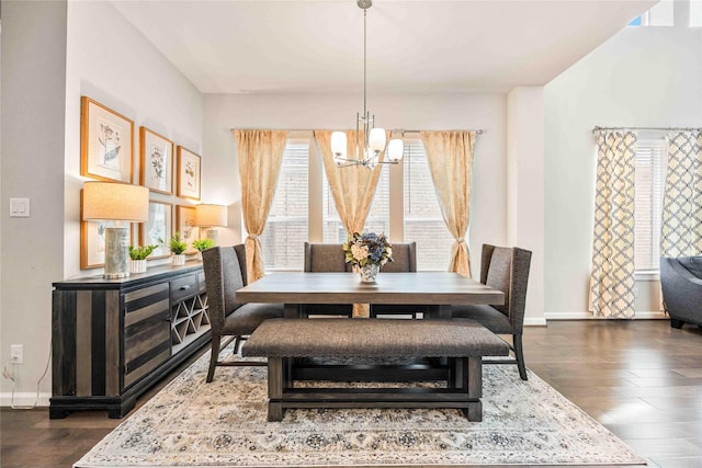 dining space with dark hardwood / wood-style flooring and an inviting chandelier