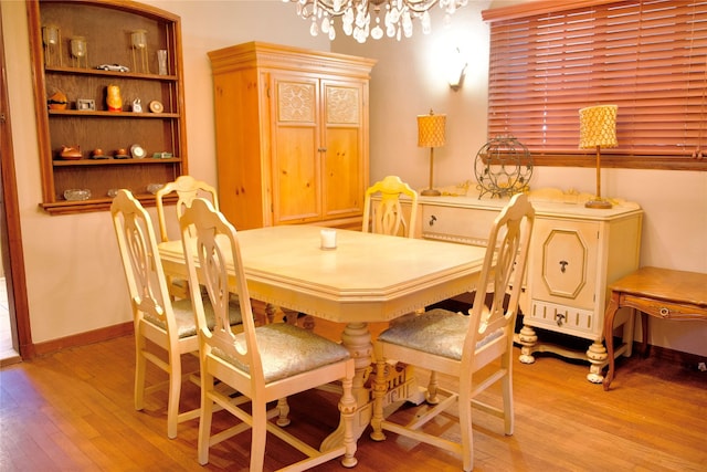 dining space featuring light hardwood / wood-style flooring and a chandelier