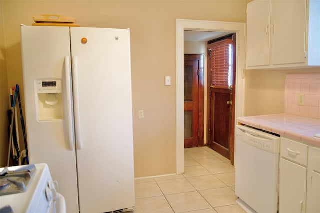 kitchen with white appliances, light tile patterned floors, tile countertops, white cabinetry, and tasteful backsplash