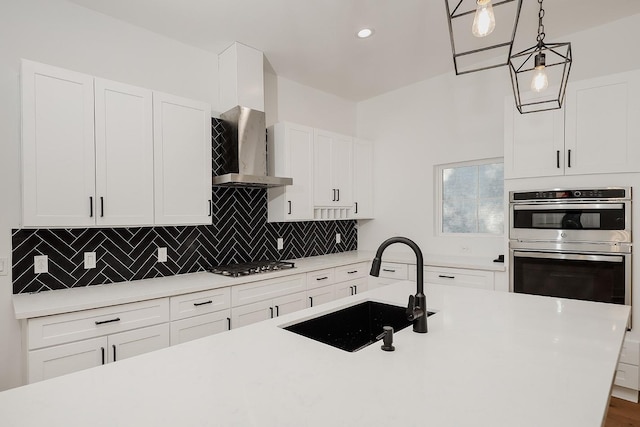 kitchen featuring sink, decorative light fixtures, and white cabinetry