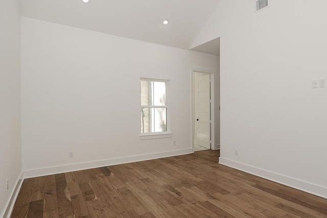 empty room featuring high vaulted ceiling and dark hardwood / wood-style floors