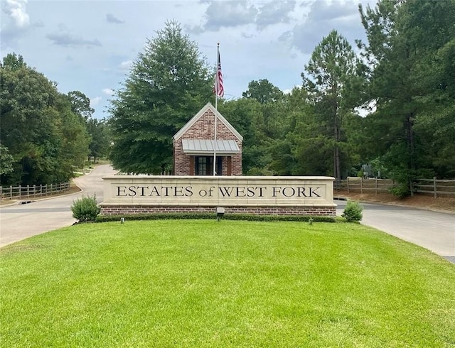 community / neighborhood sign featuring a lawn