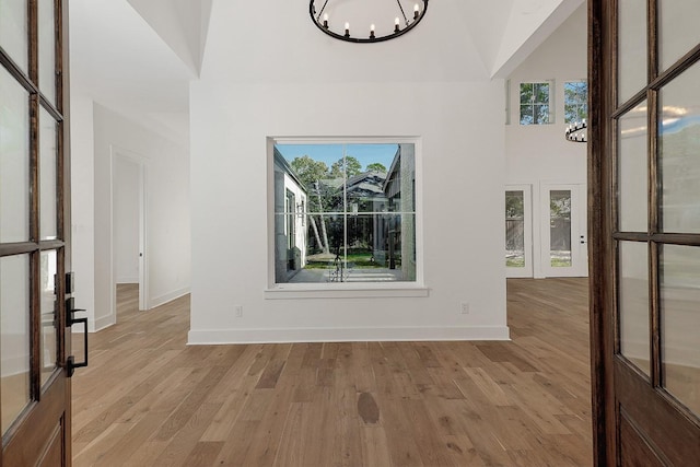 interior space featuring a notable chandelier, light wood-type flooring, and a wealth of natural light