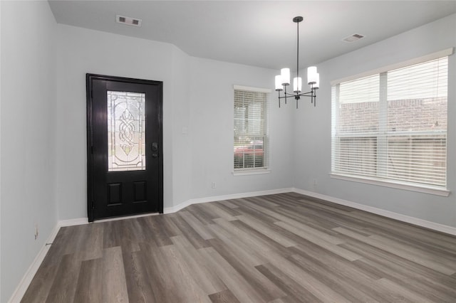 foyer entrance with hardwood / wood-style floors and a chandelier