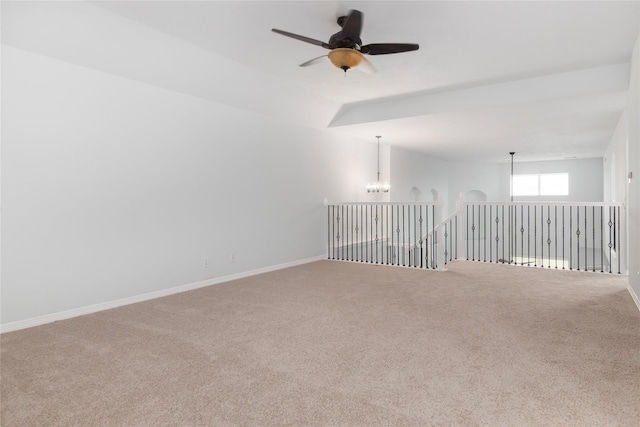 unfurnished room featuring vaulted ceiling, carpet, and ceiling fan with notable chandelier