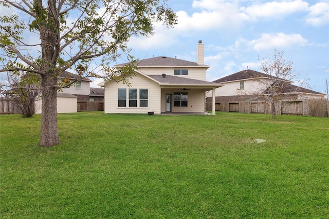 rear view of property with ceiling fan, a patio area, and a lawn