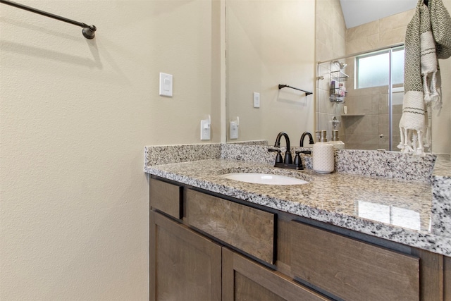 bathroom with walk in shower and vanity