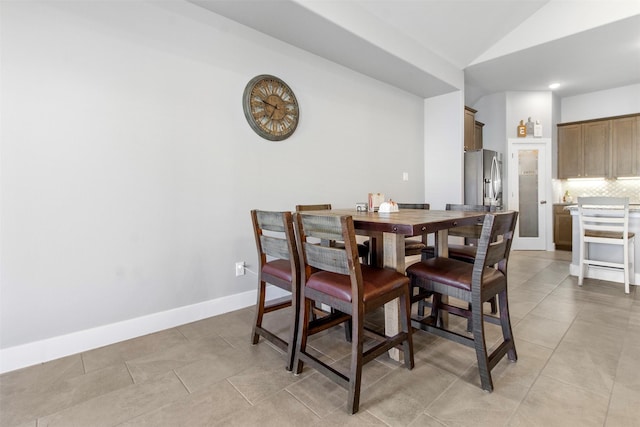 tiled dining area with vaulted ceiling