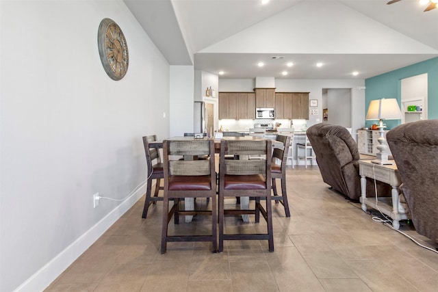 dining space featuring ceiling fan and vaulted ceiling