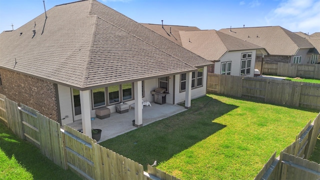 rear view of house featuring a patio and a lawn