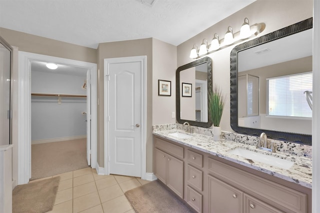 bathroom featuring a textured ceiling, vanity, and tile patterned floors