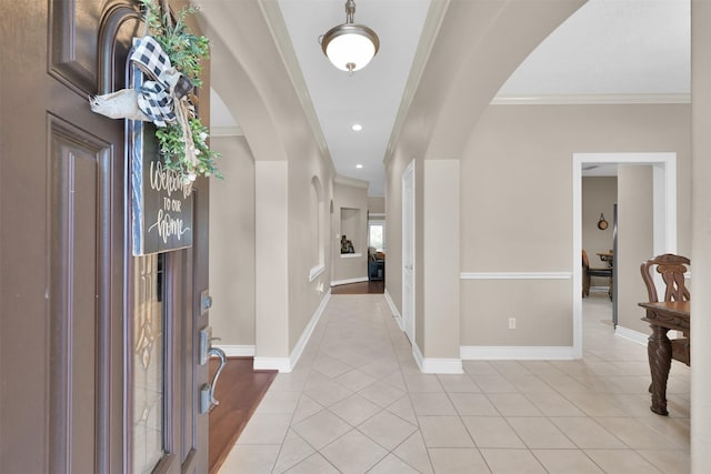 foyer featuring ornamental molding and light tile patterned floors