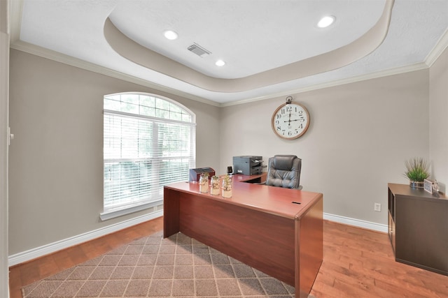 home office featuring ornamental molding, light wood-type flooring, and a raised ceiling