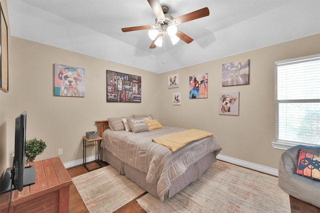 bedroom with light wood-type flooring, ceiling fan, and multiple windows