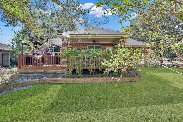 rear view of property featuring ceiling fan, a yard, and a wooden deck